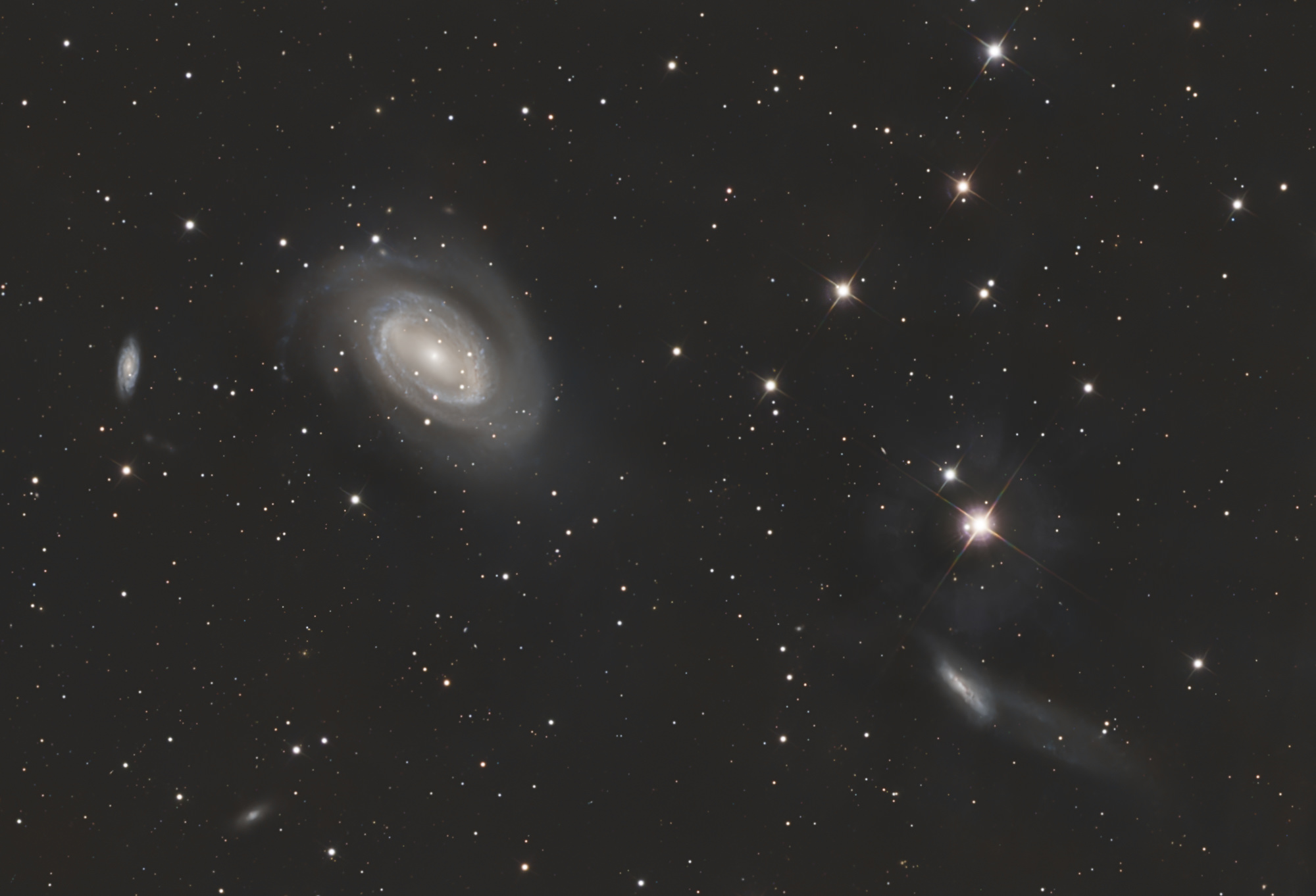 Das Holmberg-468-Galaxientriplett im Sternbild Coma Berenices enthält von links nach rechts die Galaxien NGC4712, NGC4725 und NGC4747. Die große Galaxie NGC 4725 interagiert mit der benachbarten Galaxie NGC 4747 rechts unten im Bild und besitzt ein extrem massereiches Schwarzes Loch im Zentrum.